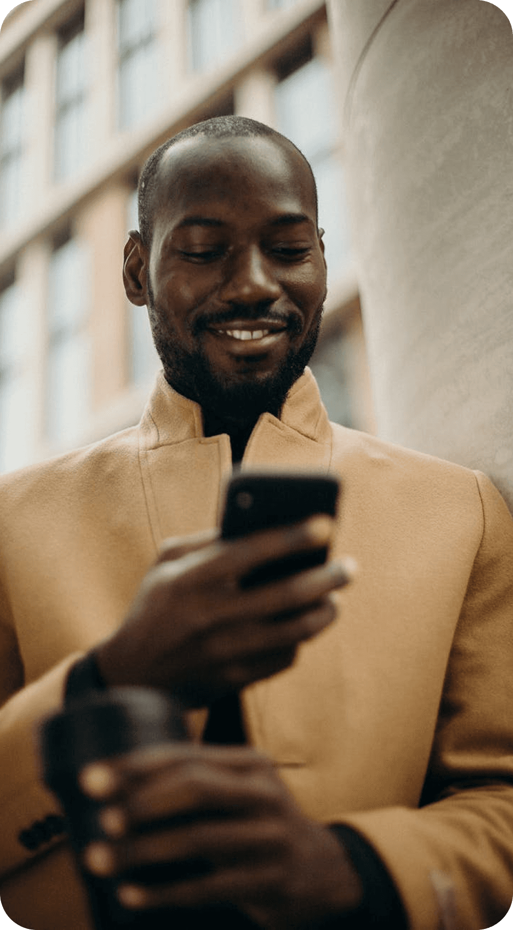 Man holding a coffee while using his phone